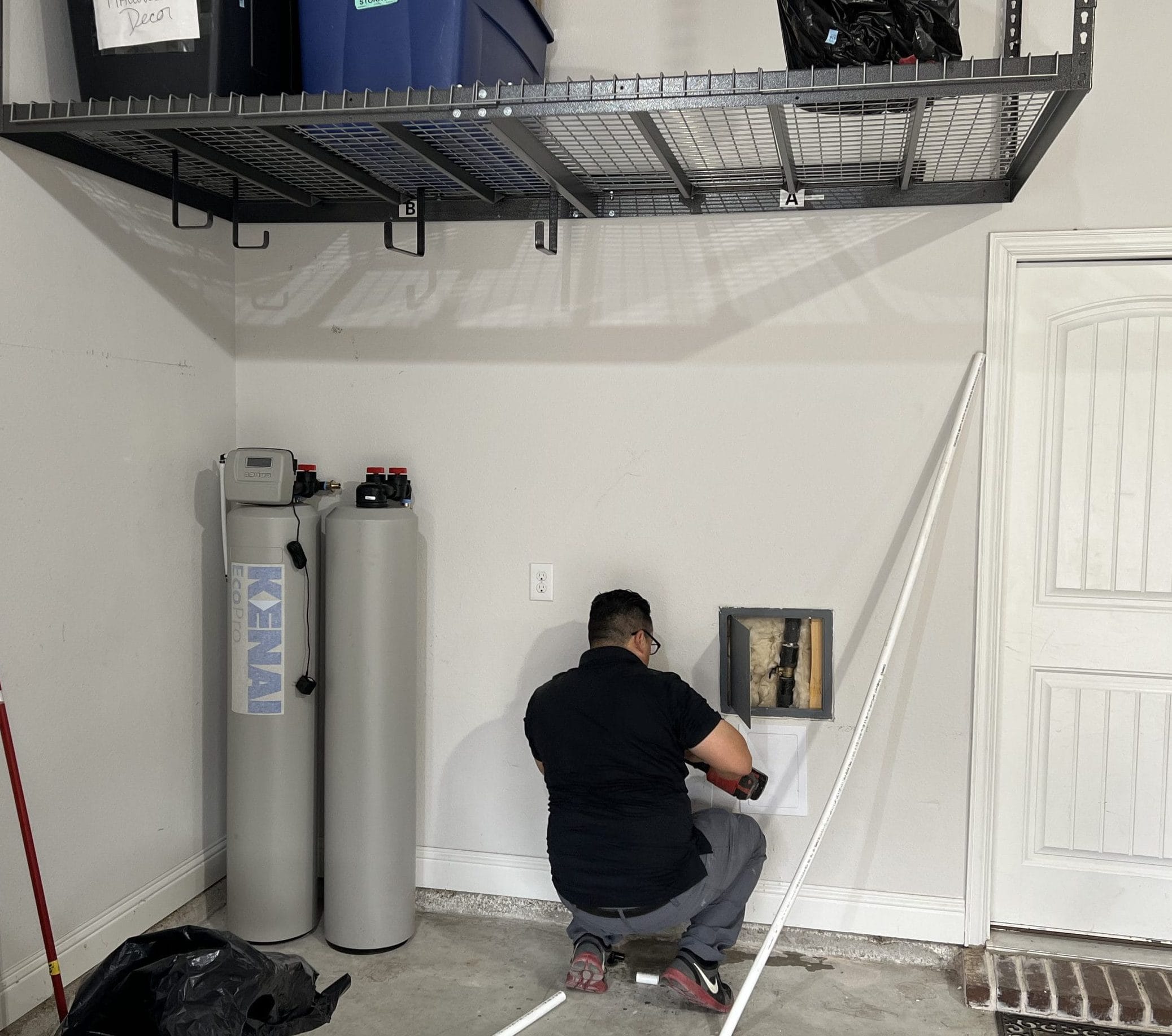 Technician Repairing Water Filtration Repairs in Garage
