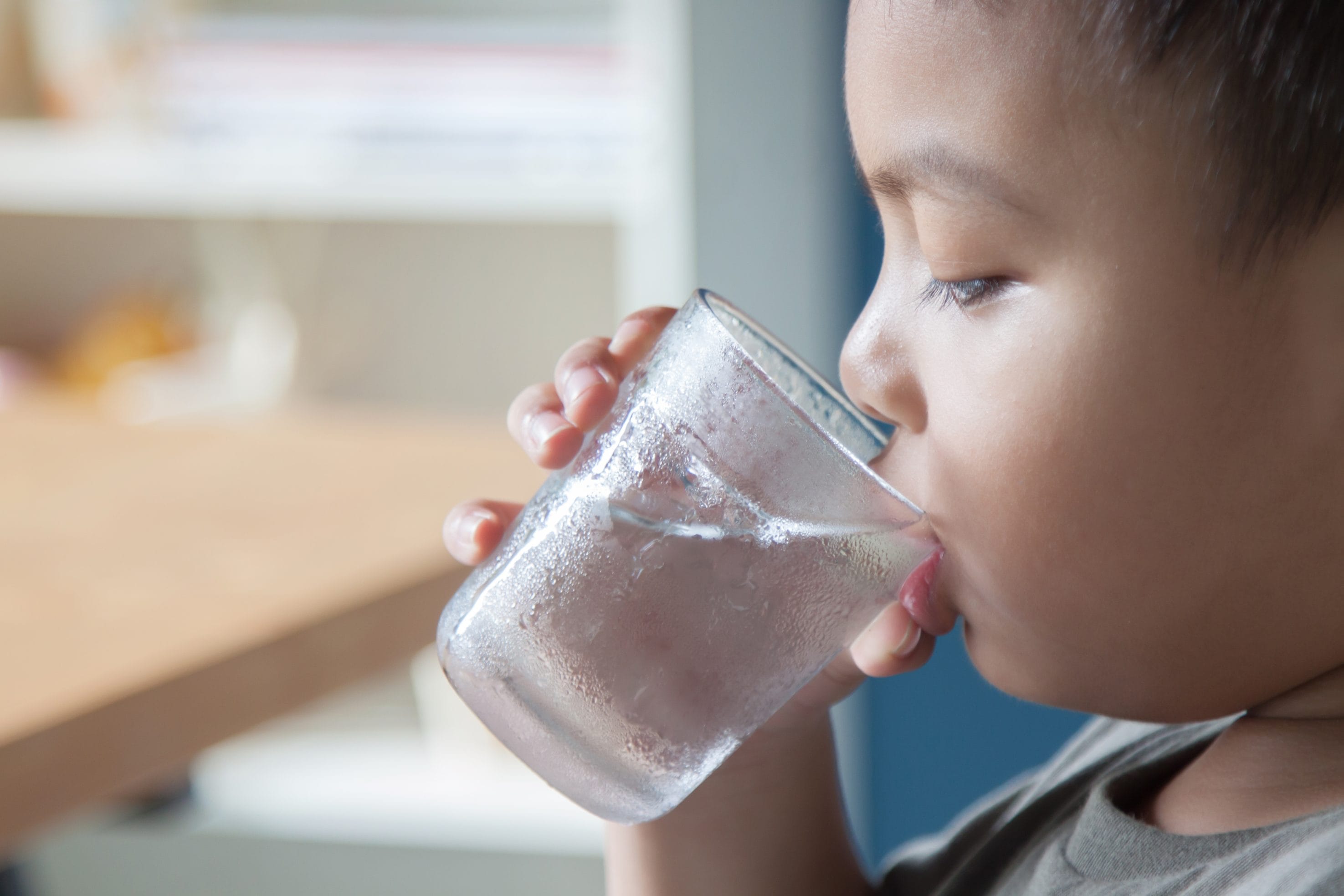 A child drinking water from a glass.